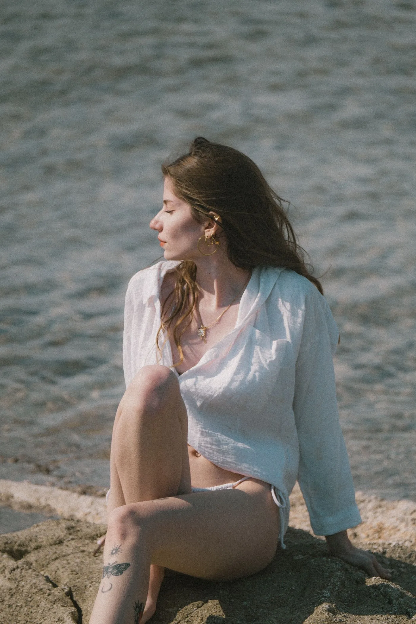 A woman in a white shirt beside the sea