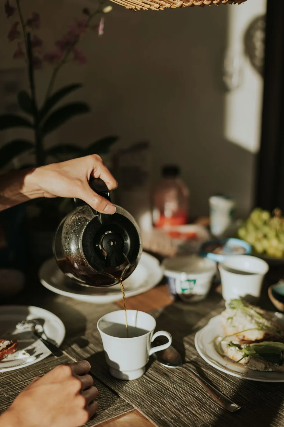 Coffee being poured from a glass vessel into a cup