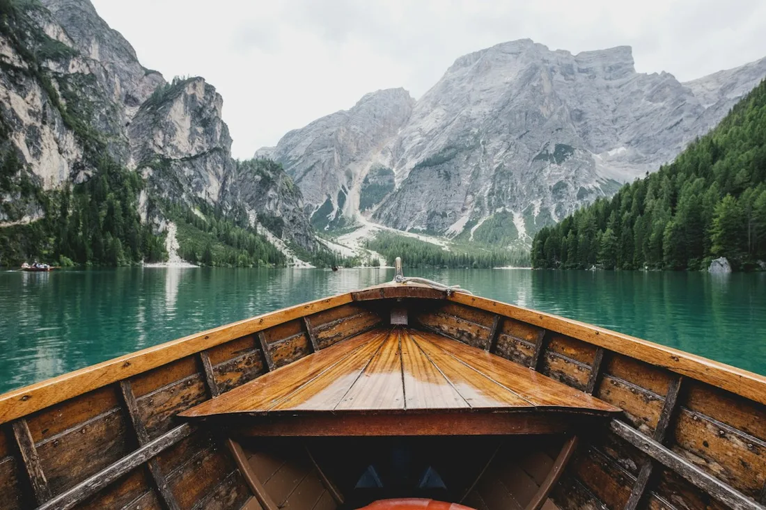 Wooden boat on a mountain lake beneath a cloudy sky