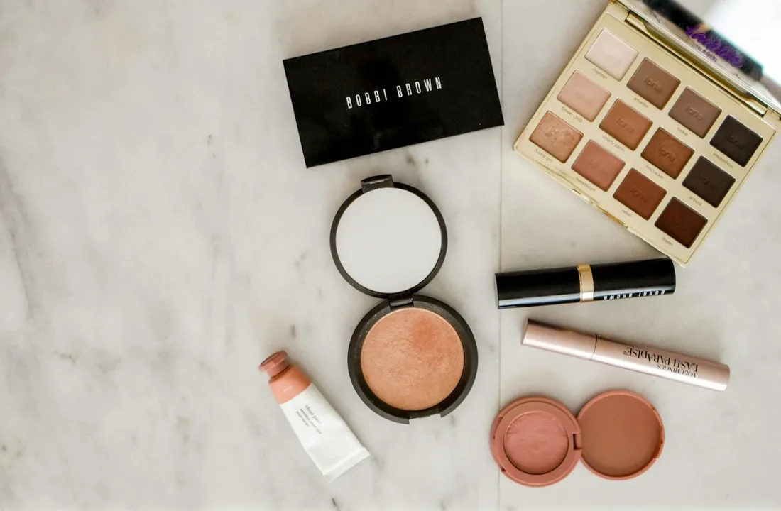 Makeup palettes and compact cosmetics arranged on a light marble surface