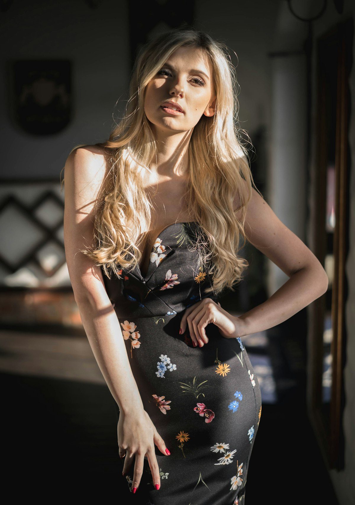 A woman wearing a dark floral dress indoors