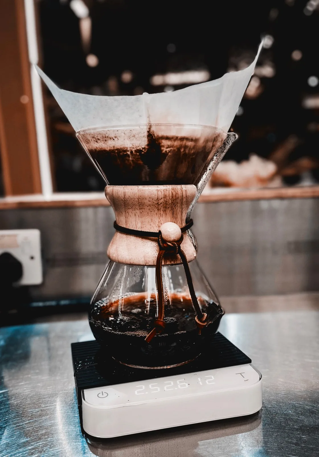 Glass coffee brewer with a filter resting on a digital scale