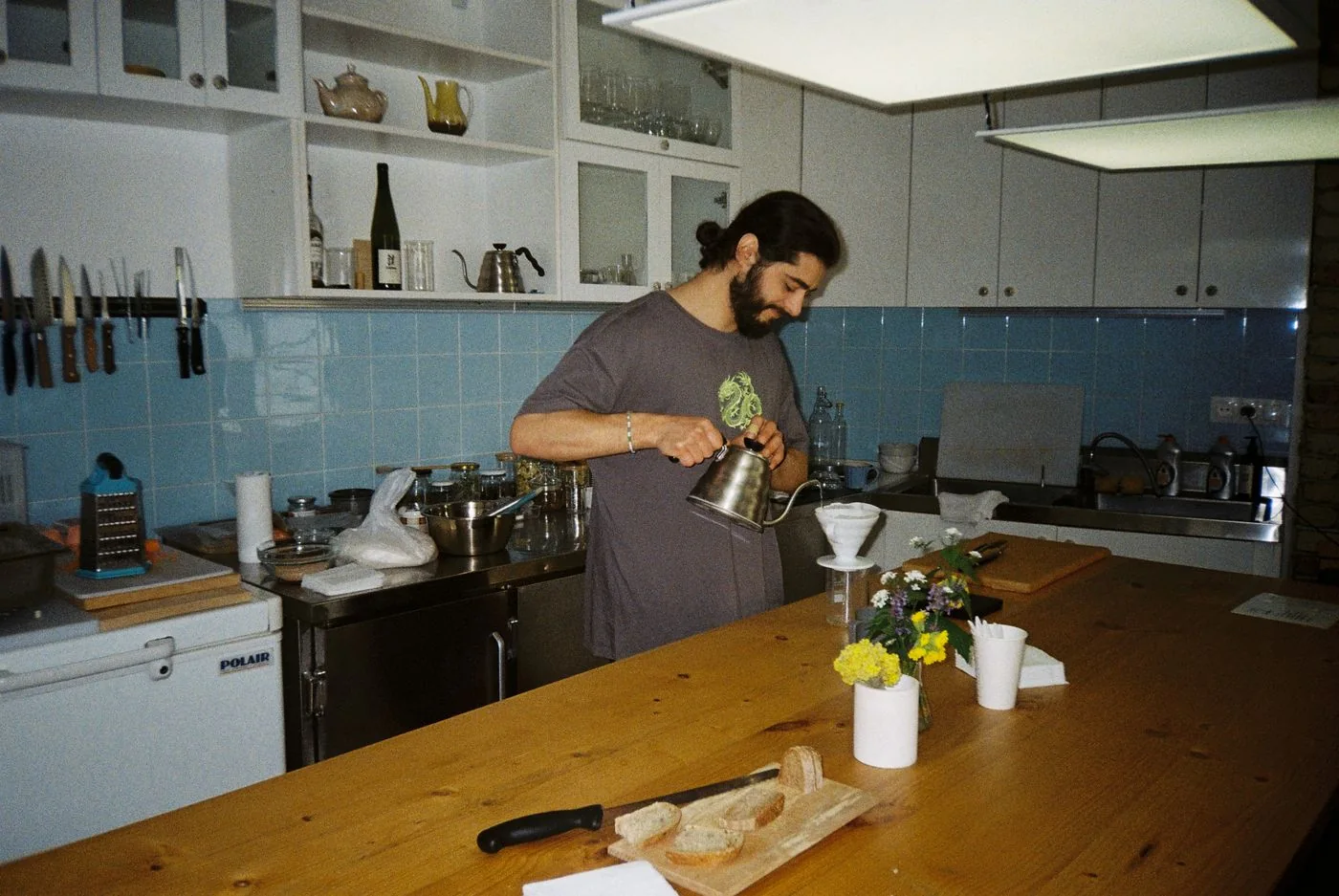 Man preparing pour-over coffee at a kitchen counter