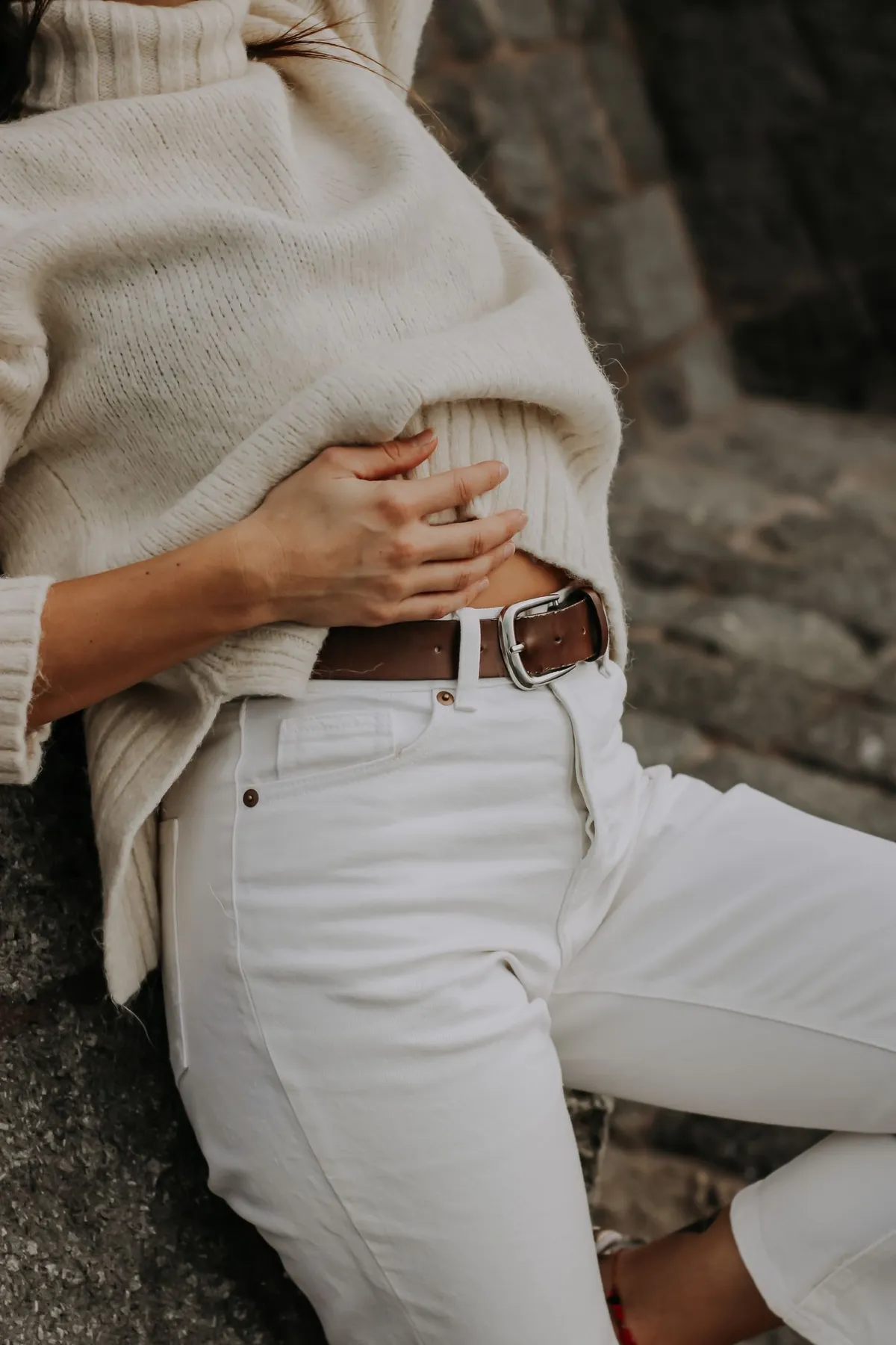 A light sweater and white jeans worn with a brown belt.