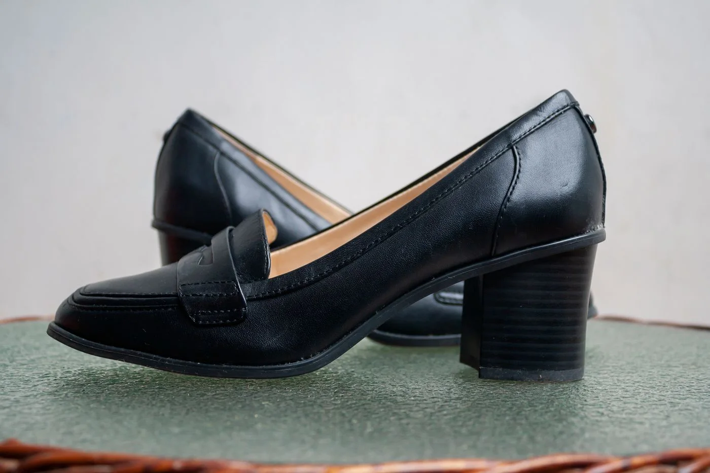 Black leather-look slip-on shoes with low block heels.