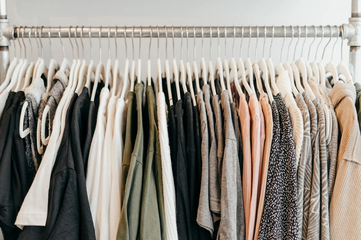 A row of clothes on hangers showing different textures and colors.